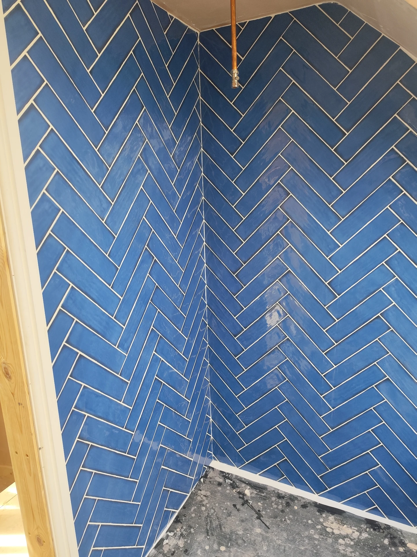 Close-up of orange zellige kitchen splashback tiles with white grout